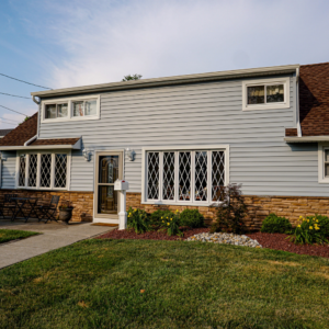Stone Veneer Base with Horizontal Siding in Light Gray and White Trim
