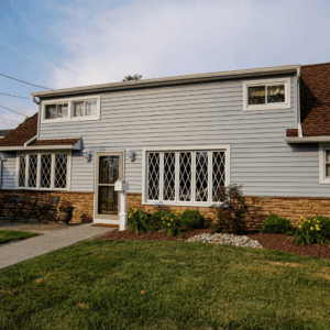 Stone Veneer Base with Horizontal Siding in Light Gray and White Trim