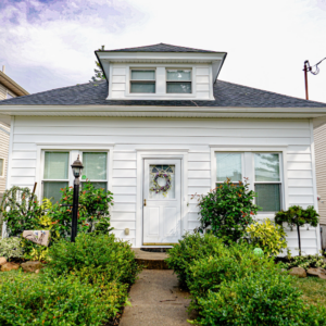 Symmetrical White Siding with Hipped Roof and Central Overhang